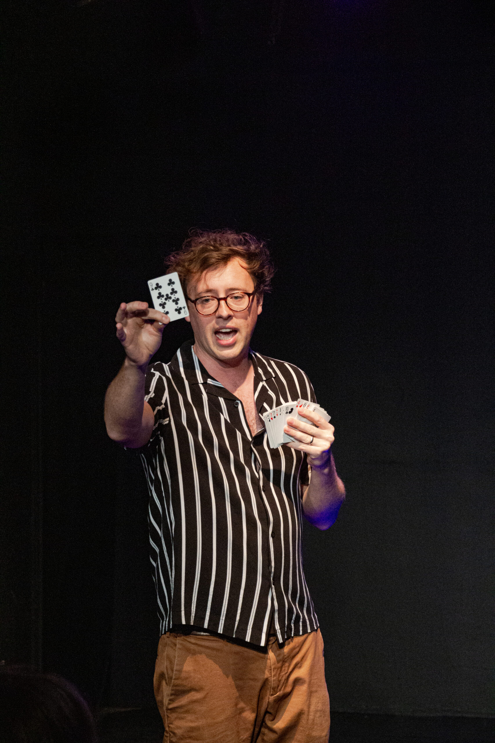Dan Titmuss with playing cards on stage