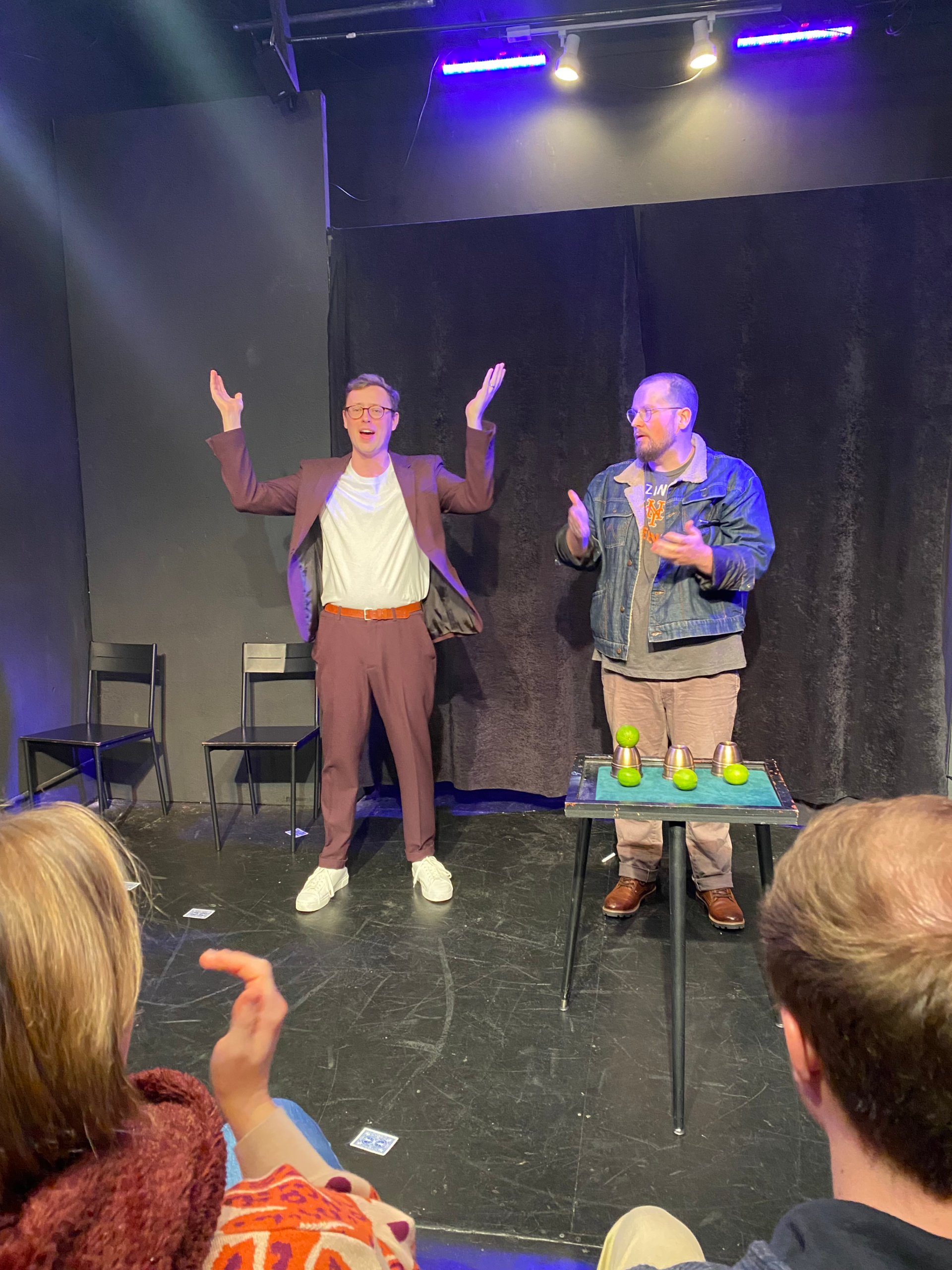 Dan Titmuss with hands raised on stage